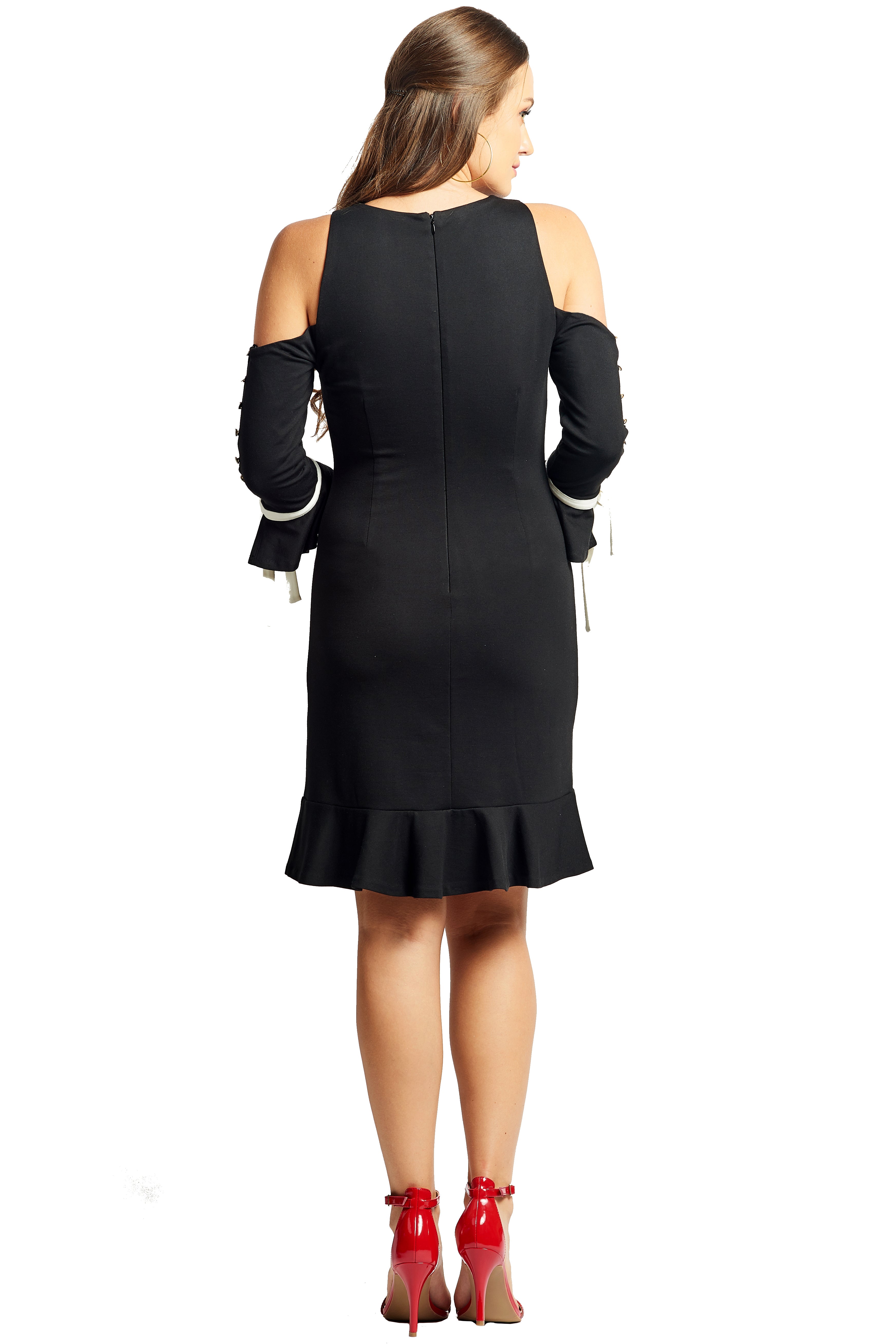Back view of model wearing above the knee black knit Ponte cold shoulder three quarter sleeve dress with bowties at sleeves, and ruffles at hems.