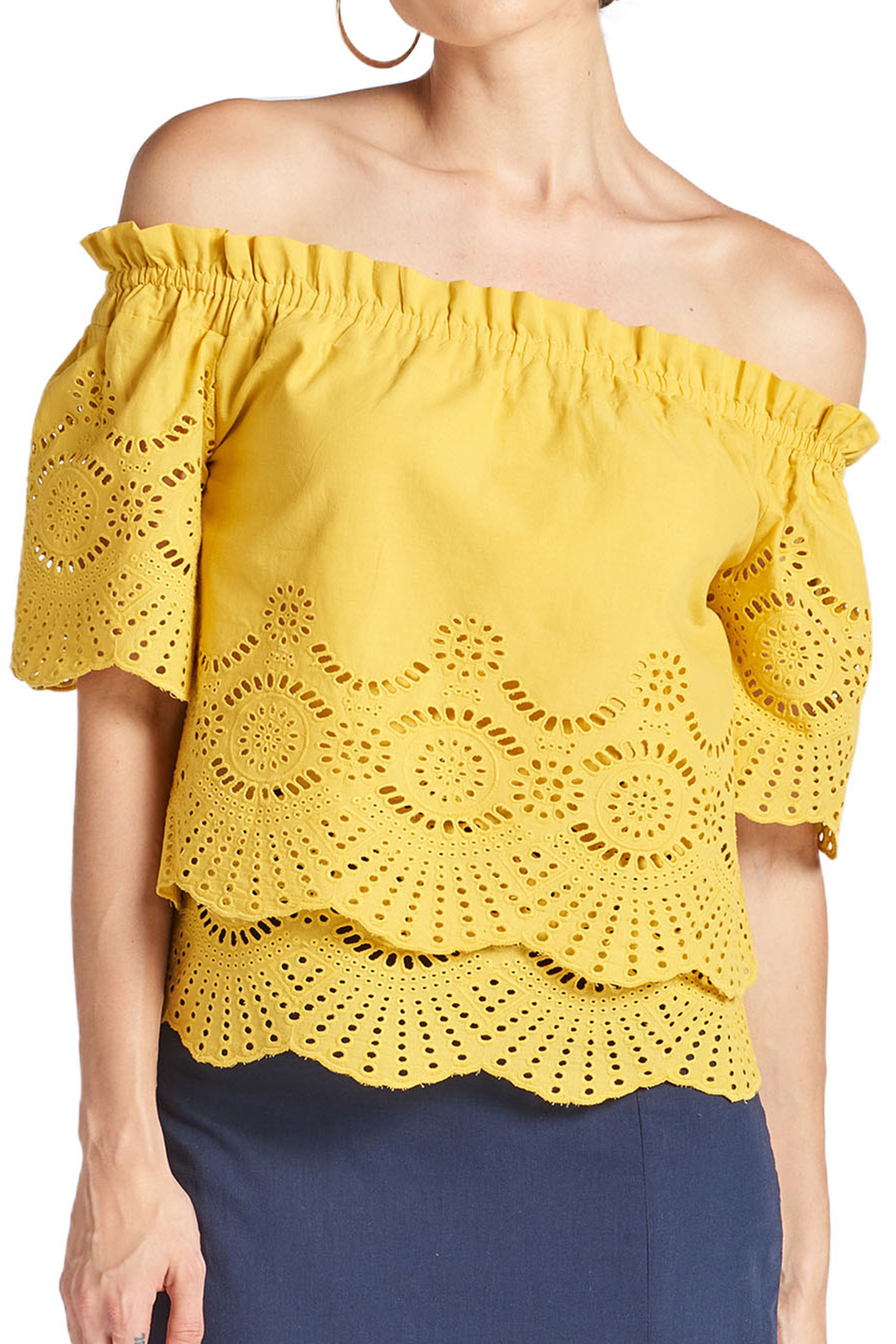 Model wearing yellow off the shoulder cotton eyelet top with scalloped short sleeves and scalloped bottom hem.