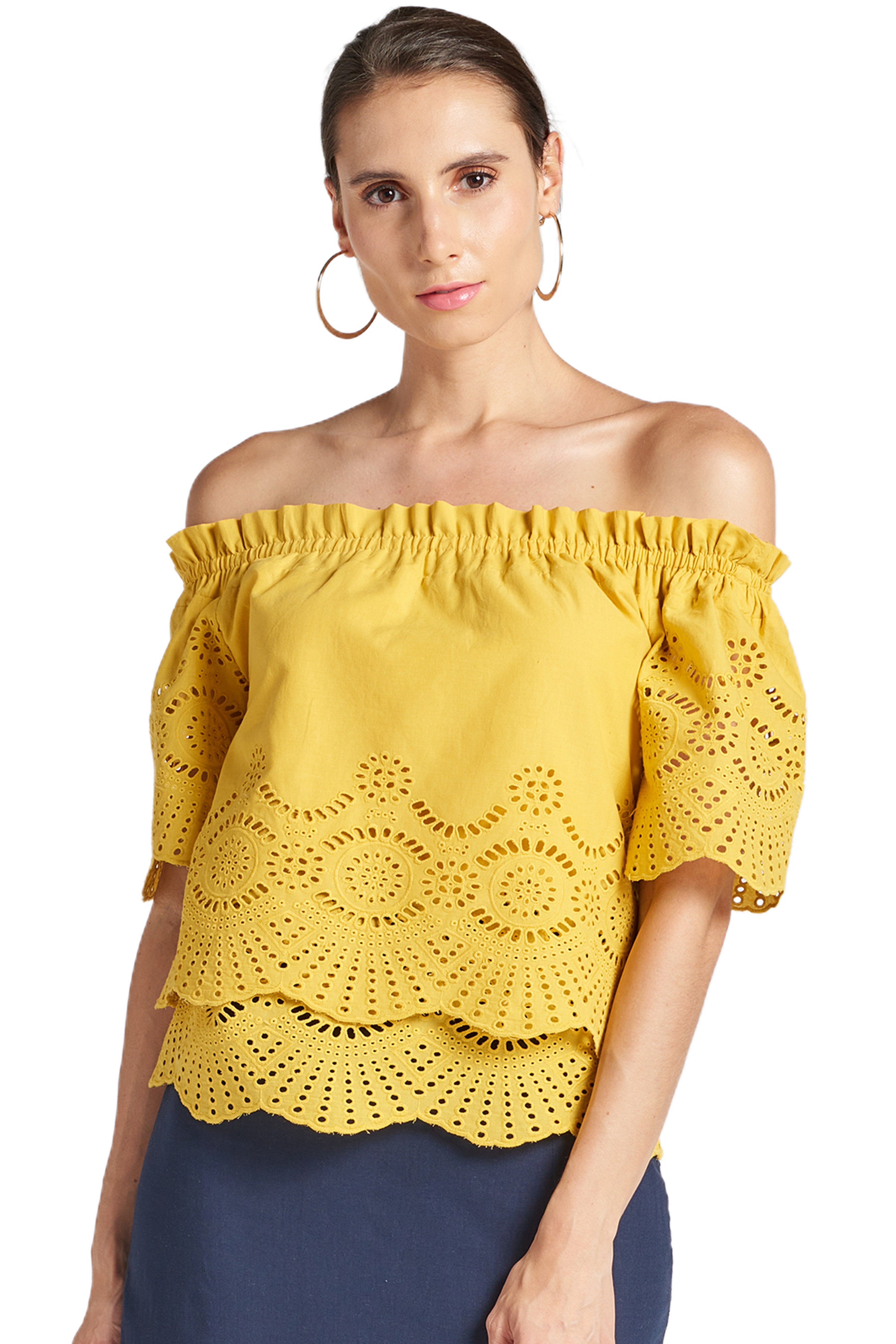 Model wearing yellow off the shoulder cotton eyelet top with scalloped sleeve hem and  scalloped bottom hem.