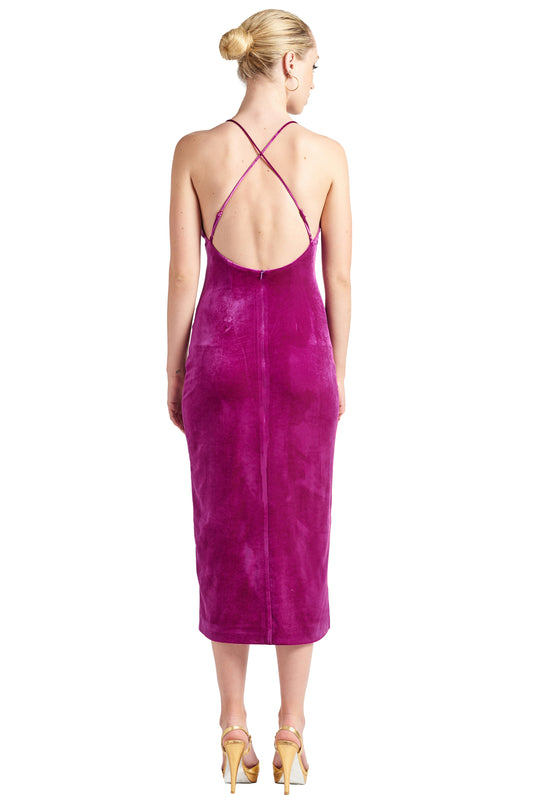 Back view of model wearing magenta stretch velvet midi dress with low back & criss cross adjustable spaghetti straps.