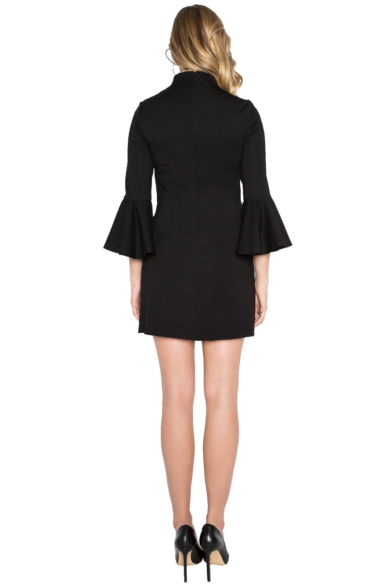 Back view of model wearing black knit Ponte mini shift dress with 3/4 bell sleeves and side slit pockets.