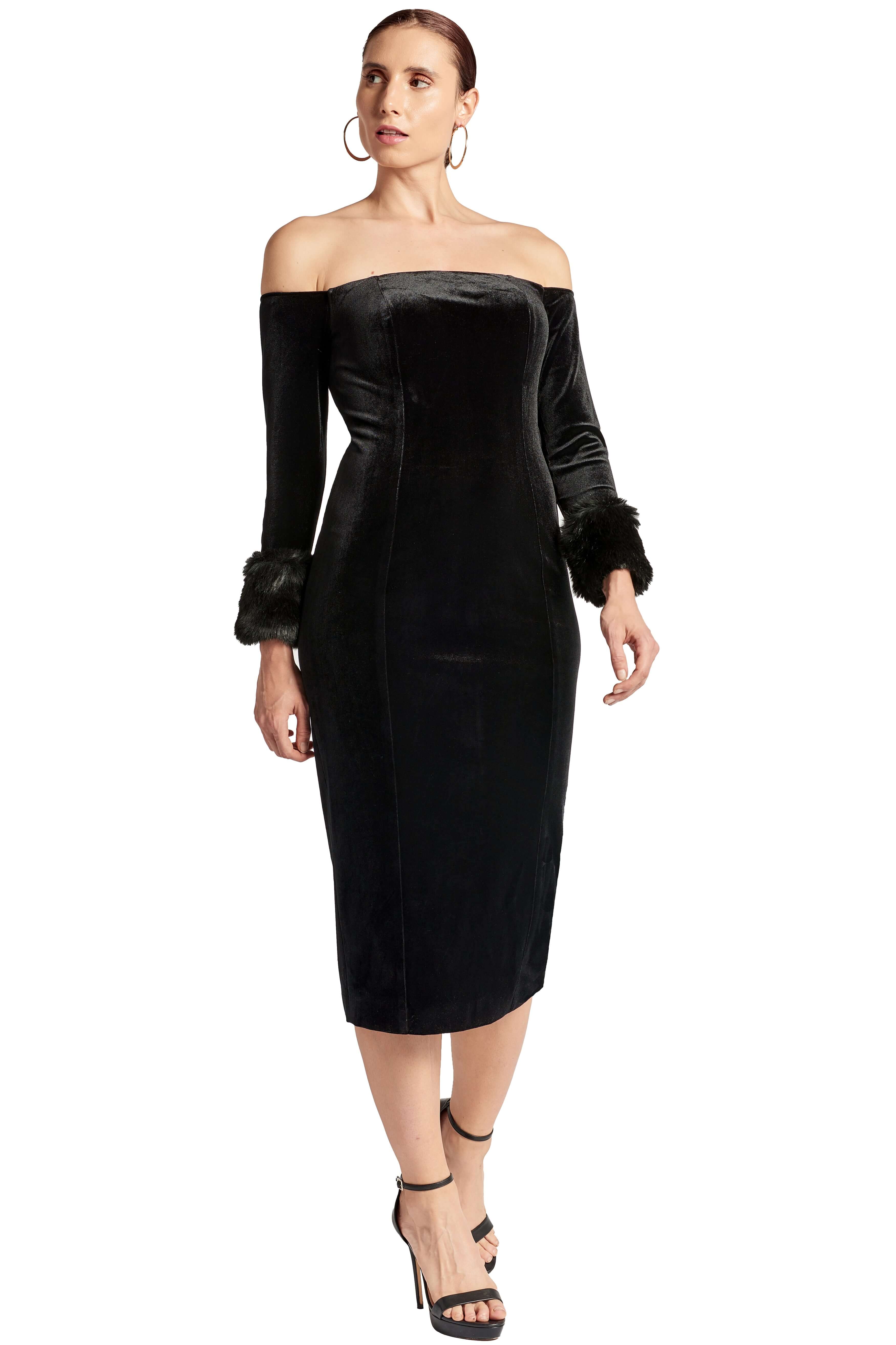 Front view of model wearing the Simona Maghen Joia Dress, off the shoulder black velvet fitted midi dress with long sleeves and faux fur cuffs.