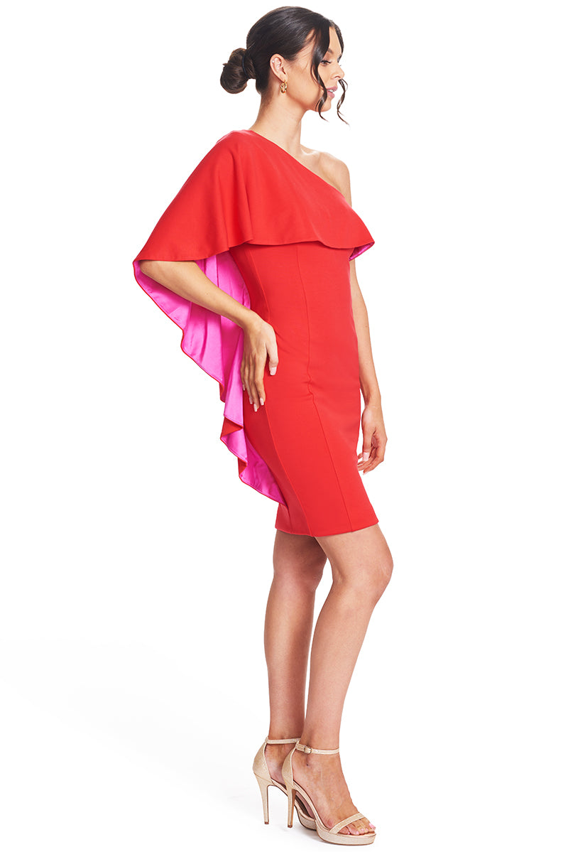 3/4 view of model wearing  the Simona Maghen Shero Dress, red above the knee body-con Ponte asymmetric cape dress with fuchsia contrast satin inside cape.