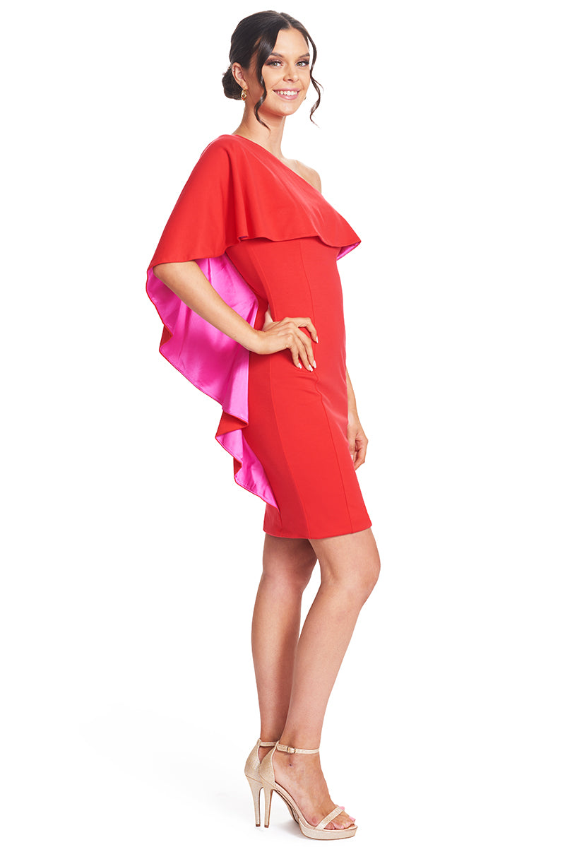 Side view of model wearing  the Simona Maghen Shero Dress, red above the knee body-con Ponte asymmetric cape dress with fuchsia contrast satin inside cape.
