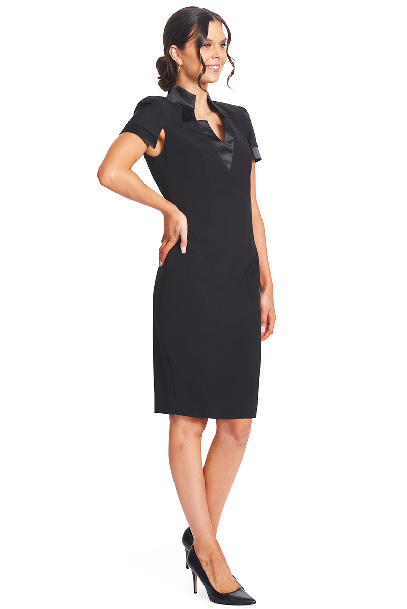3/4 front view of model wearing the Simona Maghen Top Notch Dress, notch neck high collar poly/spandex crepe sheath dress with split cap sleeves and satin contrast bands.