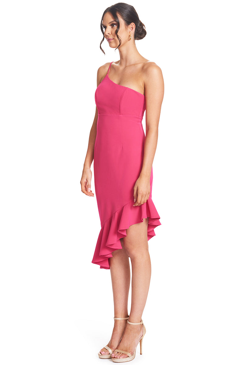 3/4 front view, with higher end of hem shown, of model wearing the Simona Maghen Rufflin' Round Dress in fuchsia, one shoulder adjustable spaghetti strap, structured bodice with boning and bra cups, and an asymmetric ruffle hem.