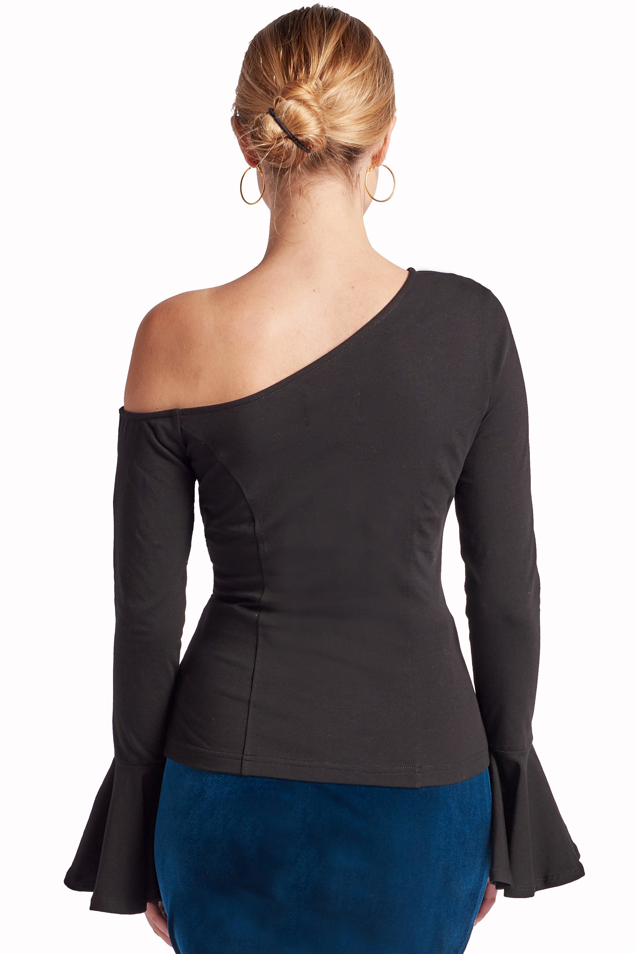 Back view of model wearing long sleeve knit black, one shoulder cut-out asymmetric bell sleeve top.