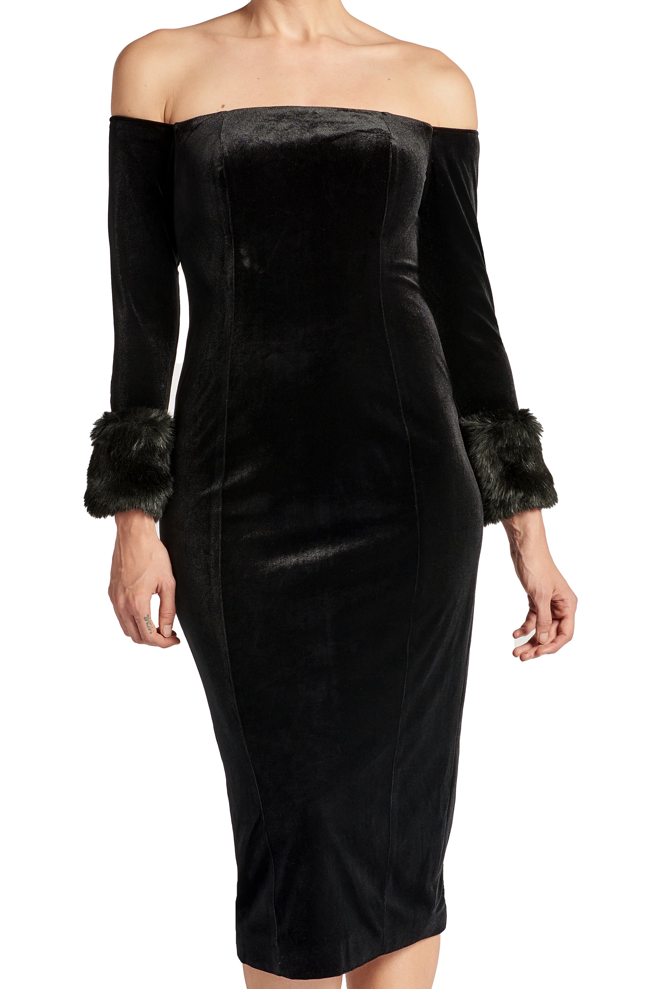 Close-up front view of model wearing the Simona Maghen Joia Dress, off the shoulder black velvet fitted midi dress with long sleeves and faux fur cuffs.