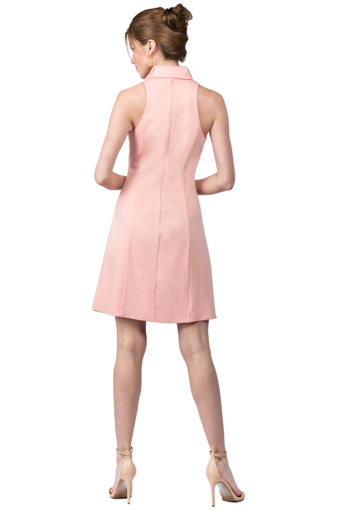 Back view of model wearing sleeveless racer neck peachy pink short fit and flare wing tip collar dress with corset lace up ties at front waist.