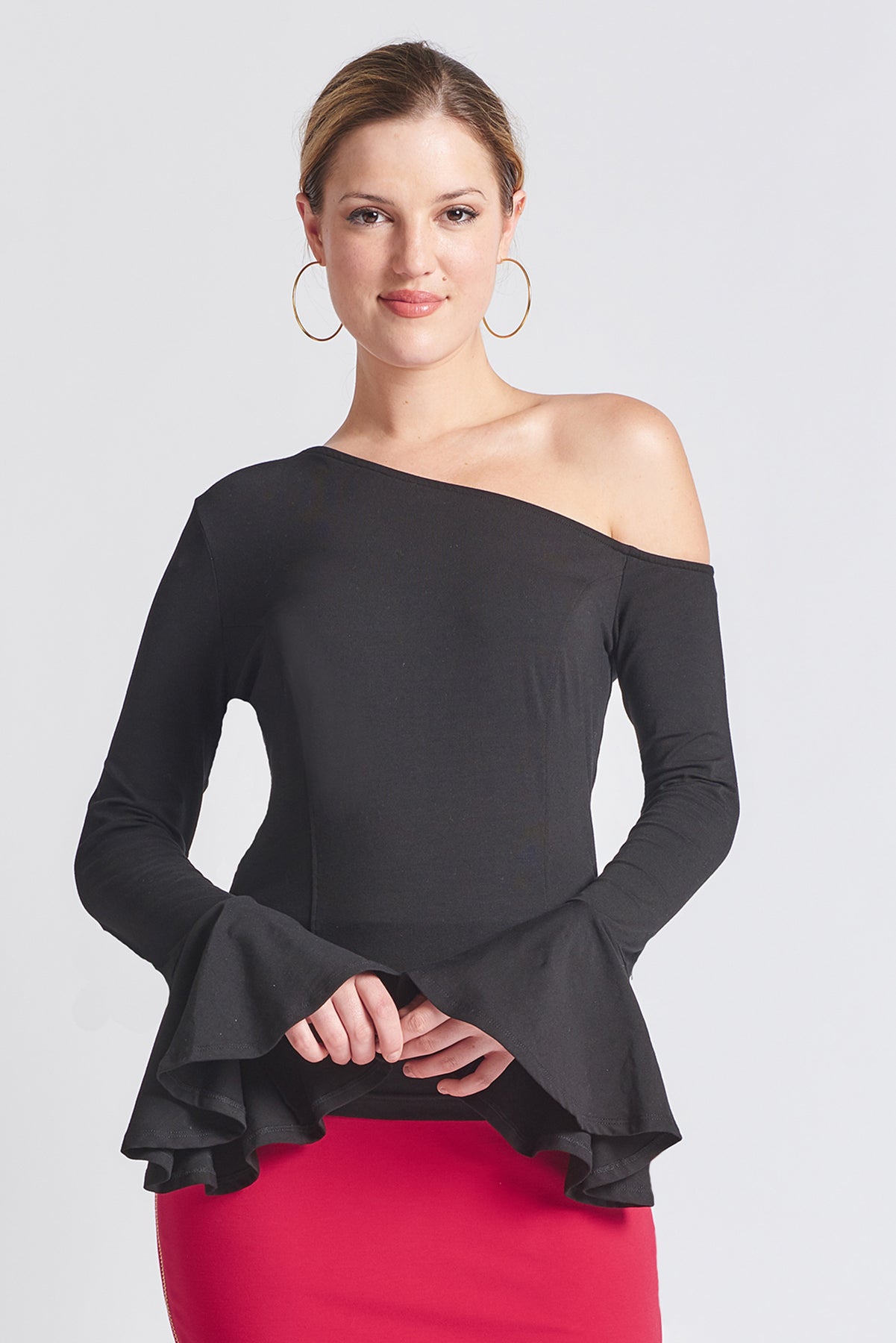 Model wearing long sleeve knit black, one shoulder cut-out asymmetric bell sleeve top.